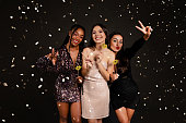 Cheerful young multiracial ladies in nice outfits celebrating Christmas
