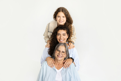 Glad happy caucasian adult mom, teen girl and old grandmother have fun, isolated on white studio background. Spare time, female generation, relationship and family, ad, offer