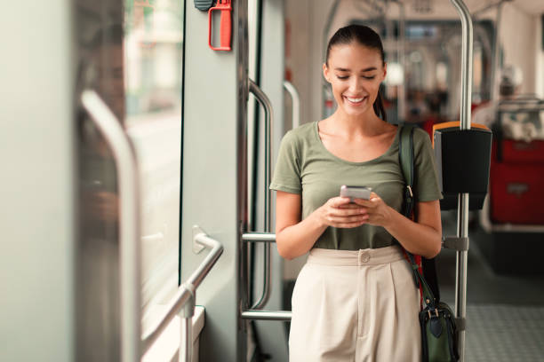 istock Joyful Passenger Woman Texting On Mobile Phone In Modern Tram 1789003570