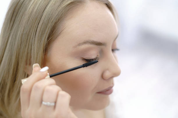 istock young woman doing her cosmetic treatment, using brush on her eyelash 1789004910