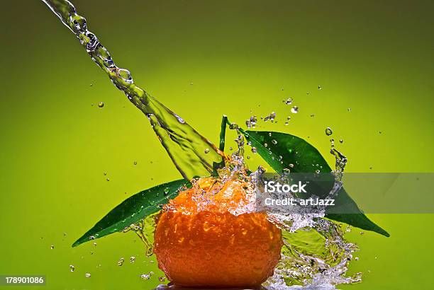 Tangerine Con Hojas Y Salpicaduras De Agua Sobre Fondo Verde Foto de stock y más banco de imágenes de Actividad