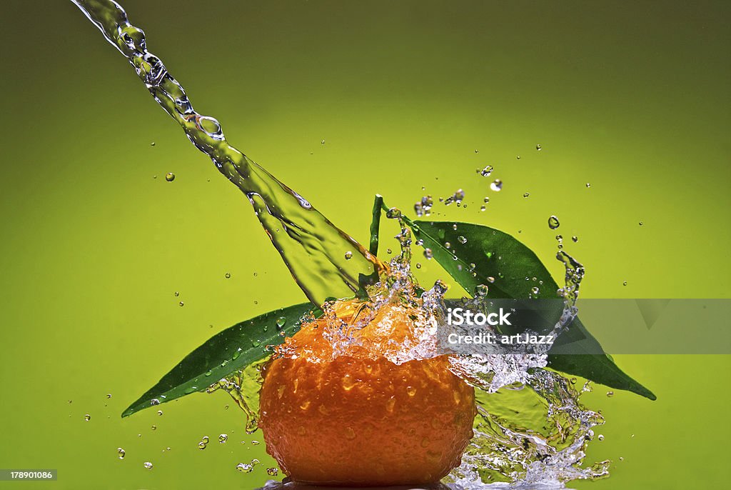 Tangerina com folhas e água splash em Fundo verde - Foto de stock de Amarelo royalty-free