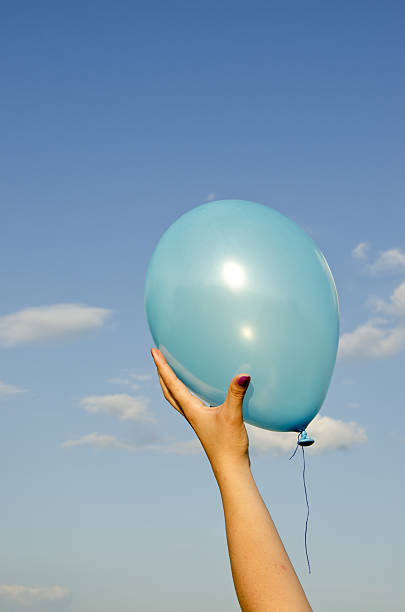 istock girl hand holding azure balloon 178901192