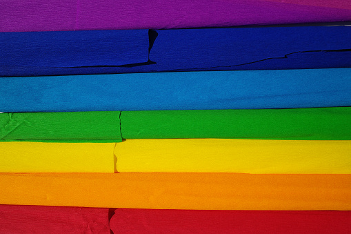 Rolls of crepe paper in the colors purple, dark blue, light blue. green, yellow, orange and red. The colors of the rainbow