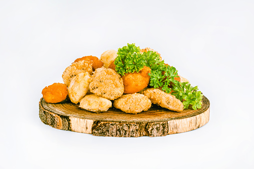 Assorted Breaded Chicken Inner Fillet,Chicken Breaded Raw Meat.Fast cooking.Breaded Chicken nuggets Fillet with salad on a White Background,food at home.Fast homemade food.Chicken breaded schnitzels.