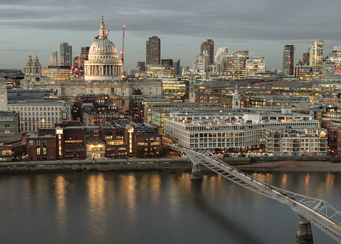 London, UK - Nov 07, 2023 - Aerial view of The City of London on the Other Side of Thames River, With St. Paul's Cathedral Rising Above All the Other Buildings with Millennium Bridge at dusk. View of Modern buildings of the London, Space for text, Selective Focus.