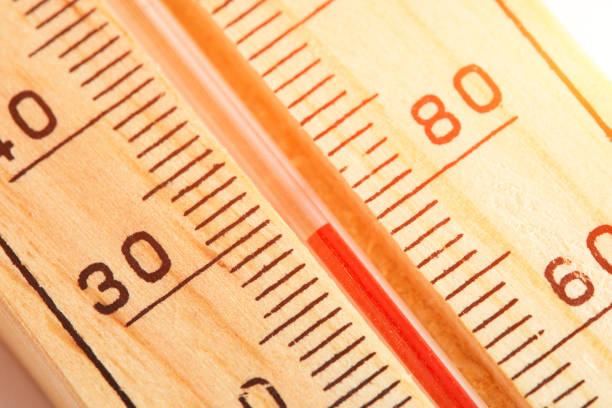 Wooden outdoor thermometer showing temperature thirty degrees Celsius and eighty degrees Fahrenheit