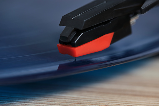 Needle of vinyl player is mounted on record. Closeup on macro photos