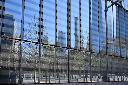 New York City, New York, USA, April 13, 2023 - Reflections in the glass facade of One World Trade Center (abbreviated 1 WTC) on Fulton St in New York.