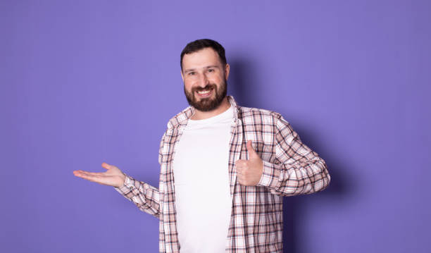 istock Positive young bearded man holding something invisible in his hands and smiling. 1789044194