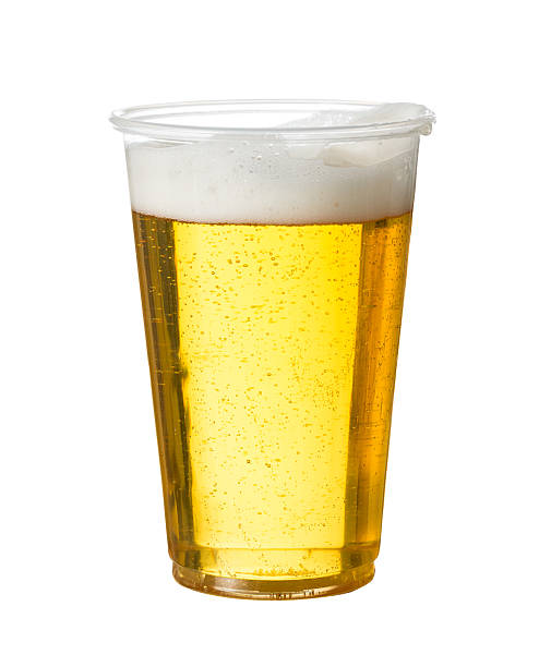 light beer in a clear plastic cup on plain white background  - wegwerpbeker stockfoto's en -beelden