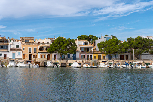 Portocolom, Spain; november 06 2023: General view of the picturesque Mallorcan town of Portocolom and its famous boat pier, at sunrise on an autumn day. Island of Mallorca, Spain