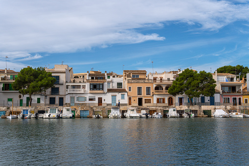 Portocolom, Spain; november 06 2023: General view of the picturesque Mallorcan town of Portocolom and its famous boat pier, at sunrise on an autumn day. Island of Mallorca, Spain