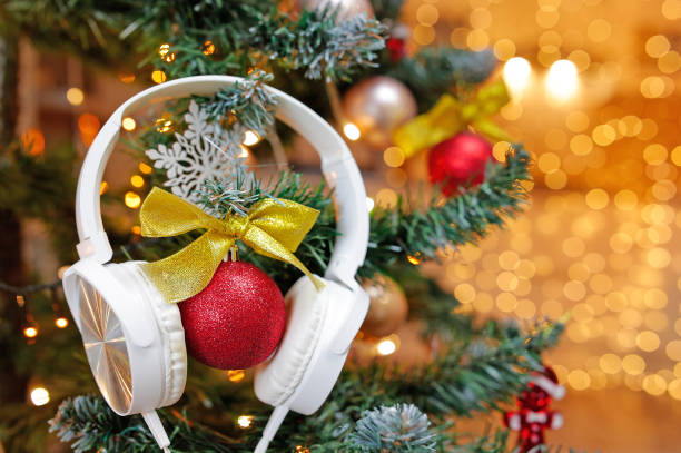 des casques d’écoute diffusent des chansons de noël et de la nouvelle musique sur le sapin de noël. - tree house audio photos et images de collection