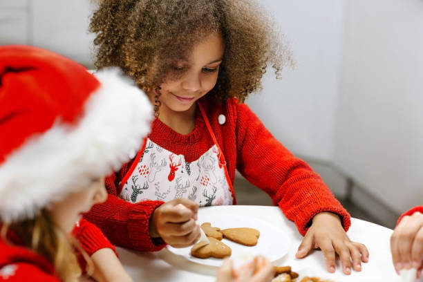 istock Relatives next to the decorated Christmas tree in the kitchen cover with icing and decorate cookies. 1789057192