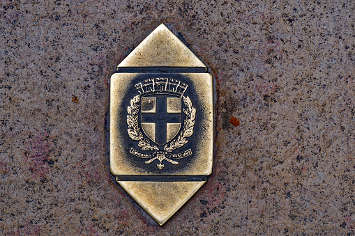 Top view of metal sign with coat of arms at floor of pavement at French City of Toulon on a cloudy late spring day. Photo taken June 9th, 2023, Toulon, France.