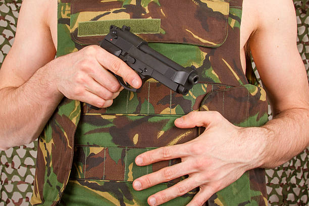 istock Soldier in camouflage vest is holding a gun 178909647