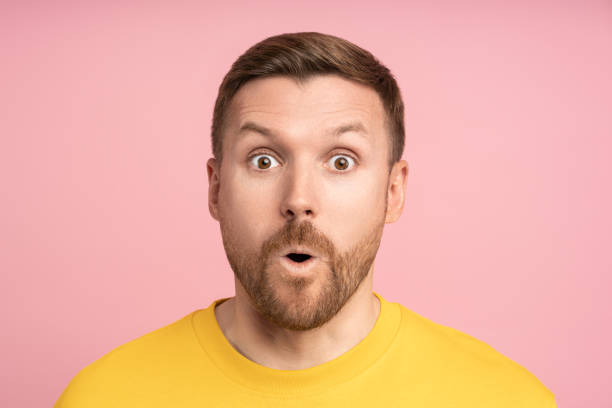 istock Amazed man looking open mouth surprised expression with big eyes, isolated pink studio background. 1789112110