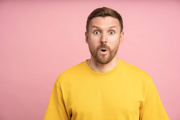 istock Amazed man looking open mouth surprised expression with big eyes, isolated pink studio background. 1789112113