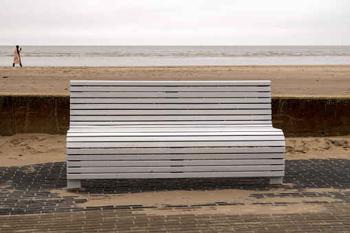 White wooden bench on the beach on the sea and background