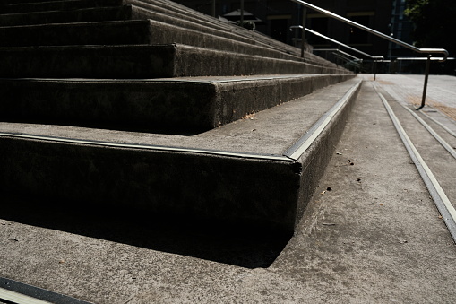 Corner of a concrete staircase on a sunny day.