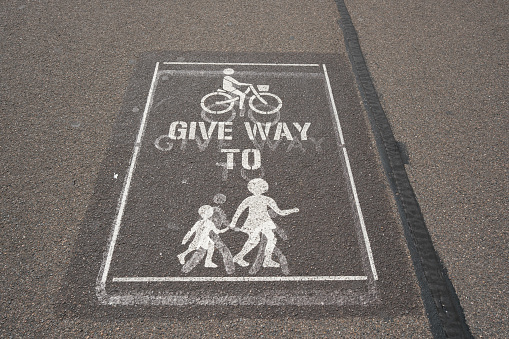 Old give way sign painted on an asphalt shared pathway.