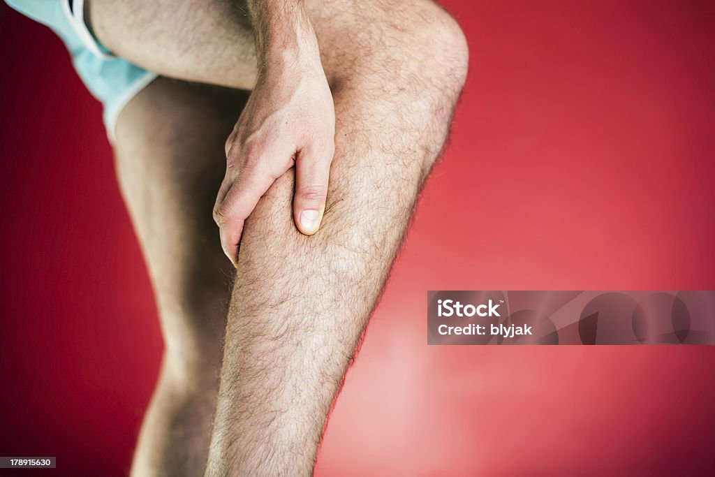 Esecuzione di lesione fisica, dolore alle gambe XXXL - Foto stock royalty-free di Adulto