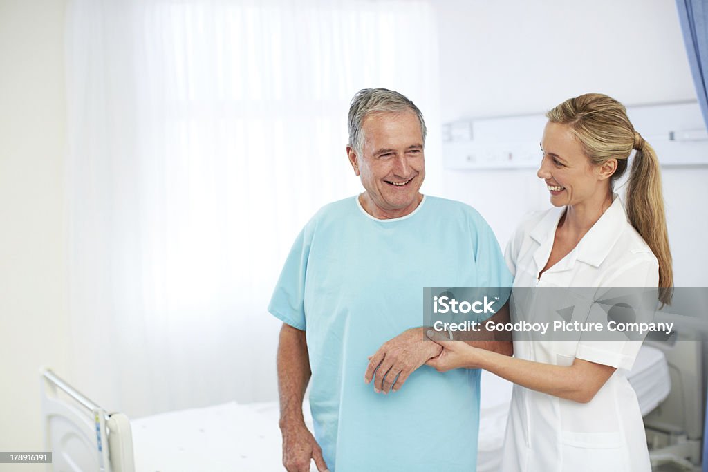 She's such a comforting presence! A smiling nurse aiding an elderly patient in a hospital ward Walking Stock Photo