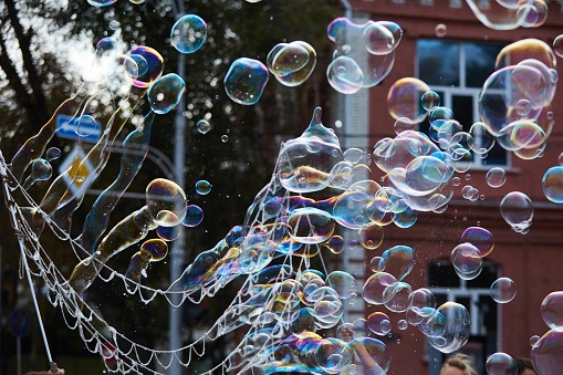 Bright soap bubbles on the city street. Close-up. The concept of a holiday and entertainment.