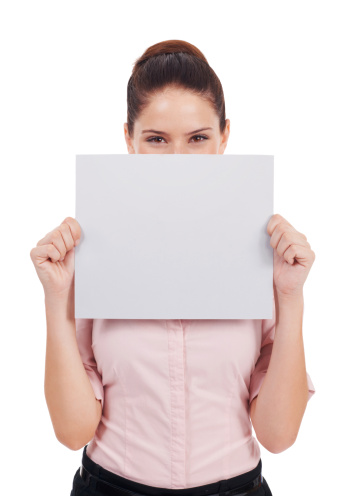 Studio shot of a young women holding up a small blank placard in front of her face isolated on white