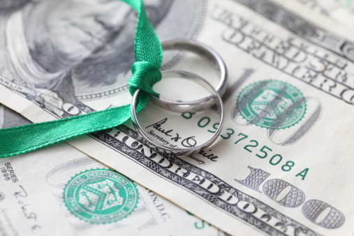 Wedding rings with green ribbon and money. Close-up.
