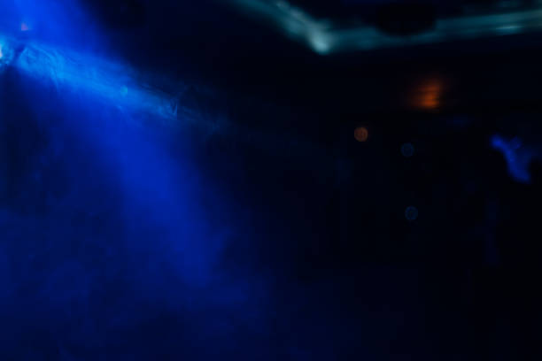 istock blue ray from the light in a dark room and smoke. 1789178975