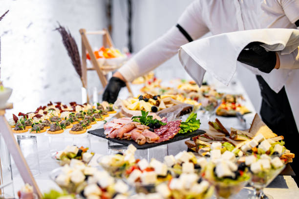 les mains d’un serveur préparent de la nourriture pour une table de buffet dans un restaurant - Photo