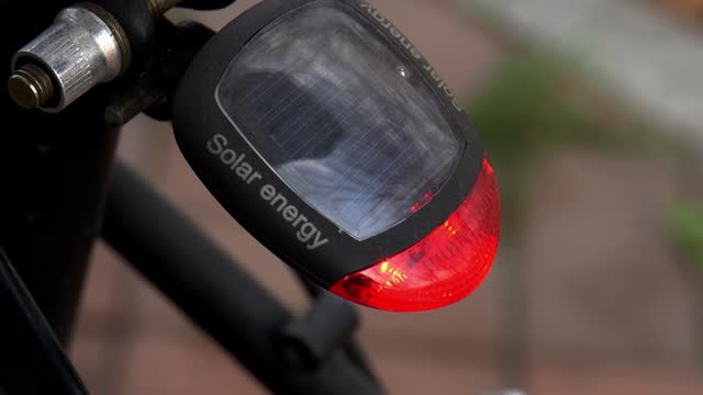 Bicycle rear lamp clearance, shines in red, safety reflector, parking light, close-up, turn on turn off