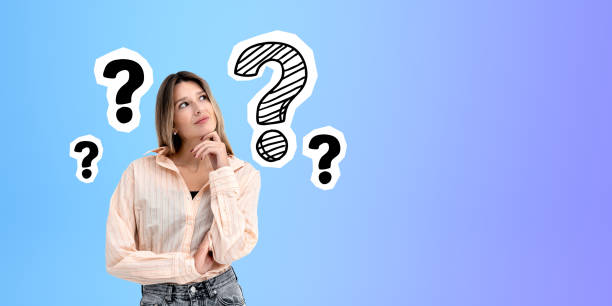 istock Pensive young woman smiling and looking up at question marks, copy space 1789194435