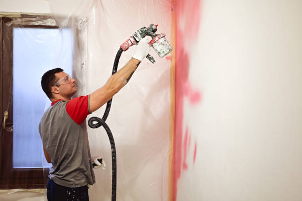 Paint spray gun at work at the workplace in the workshop. Paint Brush.