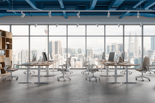 Interior of modern open space office with white walls, blue ceiling pipes and row of computer desks with beige chairs standing near panoramic window with cityscape. 3e rendering