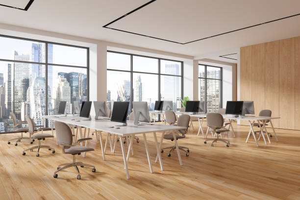 istock Modern office coworking interior with pc monitors and chairs in row, window 1789202352
