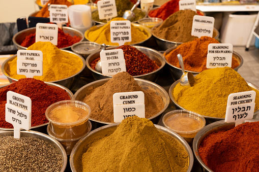 A variety of spice powders, including cumin, paprika, black pepper and chicken seasoning on sale in a spice stall in Jerusalem's Machane Yehuda outdoor market.