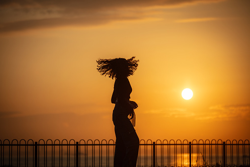 Silhouette of young lady at sunset.