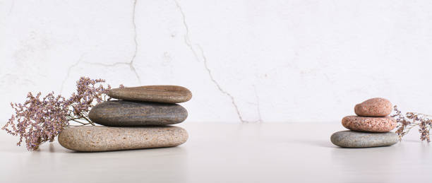 istock Pattern of smooth flat sea stones and dried flowers on the table web banner 1789290892