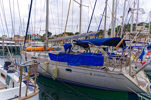 Marina with sailing boats and yachts at French village of Saint-Mandrier-sur-Mer on a cloudy late spring day. Photo taken June 9th, 2023, Saint-Mandrier-sur-Mer, France.