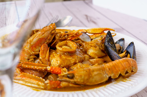 Traditional Catalan fish stew romesco de peix with prawns, mussels and fish as top view