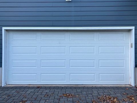 Suburban living, two car garage door with blue house siding