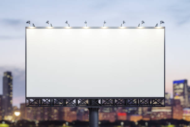 istock Blank white billboard on city buildings background at night, front view. Mockup, advertising concept 1789305675