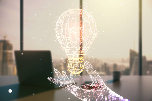 istock Creative light bulb hologram and modern desk with computer on background, idea concept. Multiexposure 1789306783