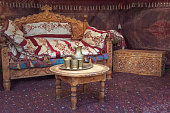 Traditional Asian silver jug and cups stand on an old wooden table in a yurt - the home of nomads.