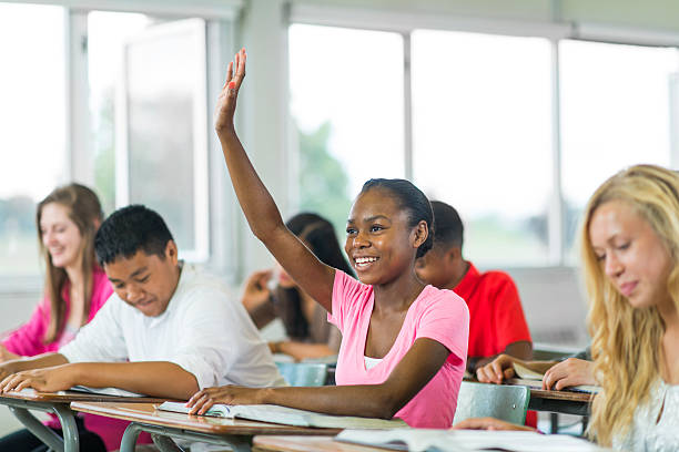 Diverse High School Students Diverse high school classroom teenage high school girl raising hand during class stock pictures, royalty-free photos & images