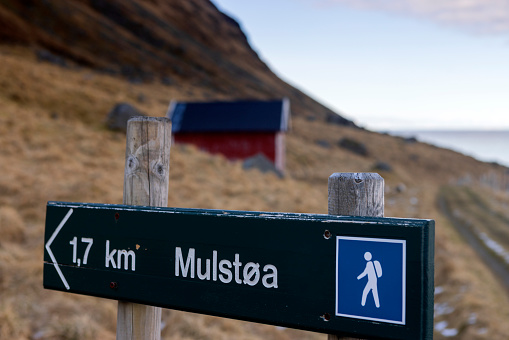 directional sign to the Mulstoa trail on the Lofoten Islands, a coastal path towards the northernmost side of the island.
The path takes leads to a spectacular view over the Ytresand beach towards the peaks of the Flakstadøya Island; Lofoten, Norway