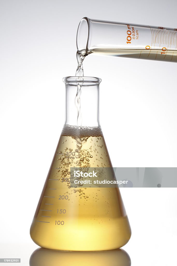 Lab フラスコと注ぐ液体ます。 - ビーカーのロイヤリティフリーストックフォト